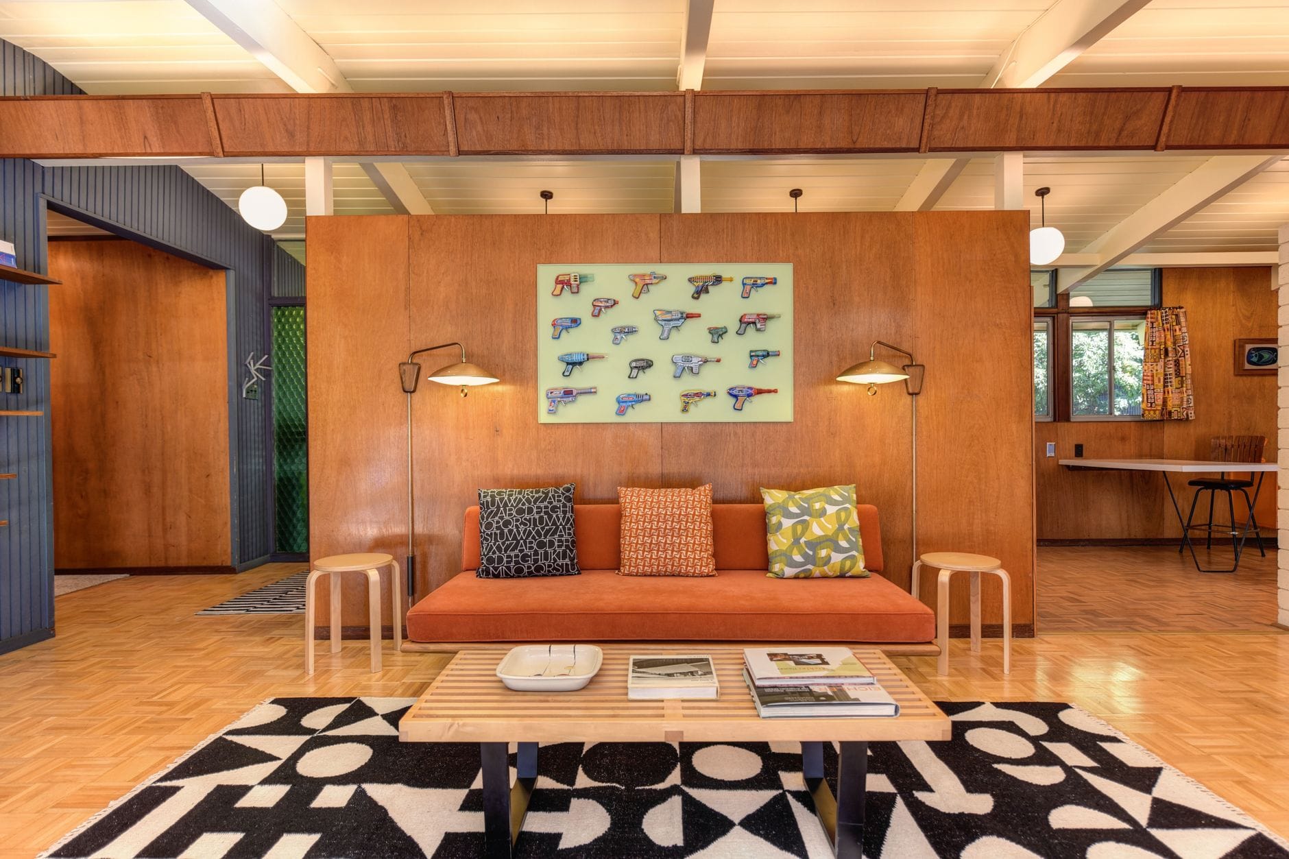 Salon mid-century modern z drewnianymi meblami i ciepłymi dodatkami