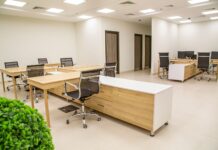 Przestronne biuro z drewnianymi biurkami i ergonomicznymi krzesłami